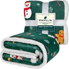 the green christmas blanket has snowmen on it and is folded up in two rows