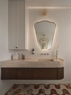 a bathroom with a sink, mirror and rug on the floor in front of it