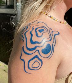 a woman with a blue tattoo on her shoulder