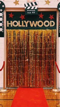 a red carpet on the floor in front of a hollywood door with gold streamers