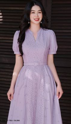 a woman in a purple dress posing for the camera