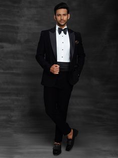 a man in a tuxedo poses for a photo