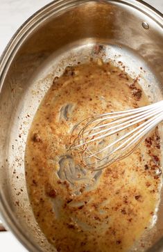 a metal bowl filled with food and whisk