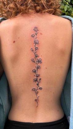 the back of a woman's body with flowers on her left side and behind her