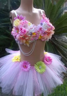 a mannequin dressed in pink, yellow and white flowers with pearls on it