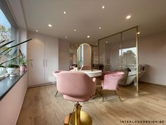 a dining room with pink chairs and a large mirror on the wall next to it