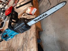 a chainsaw sitting on top of a wooden table next to other tools and equipment