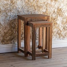 two small wooden tables sitting on top of a hard wood floor next to a wall