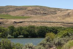 a river running through a lush green hillside