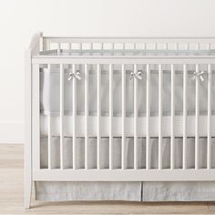 a white crib in a room with wood floors