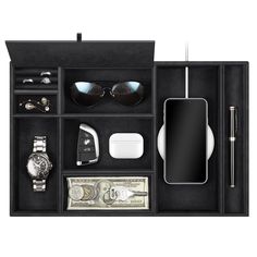 an assortment of personal items is displayed in a black case with sunglasses, money and pen