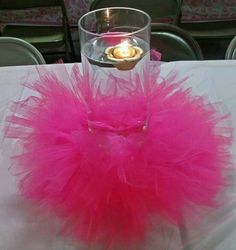 a pink tutu skirt sitting on top of a table next to a lit candle