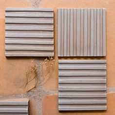 three different types of tiles on a wall with plants growing out of one side and the other