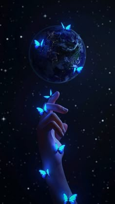 a woman's hand holding a glowing blue butterfly in front of the earth and stars