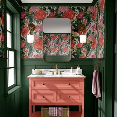 a bathroom with green walls, pink vanity and floral wallpaper on the walls above it