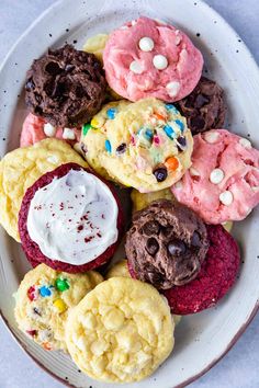 a white plate topped with cookies covered in frosting and sprinkles