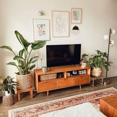 a flat screen tv sitting on top of a wooden entertainment center in a living room