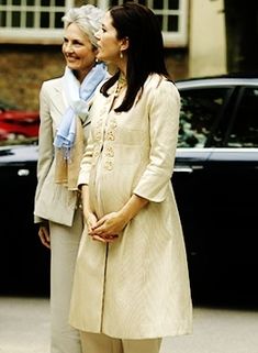 two women standing next to each other in front of a car