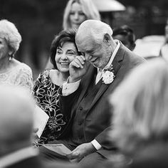 a man and woman sitting next to each other at a wedding