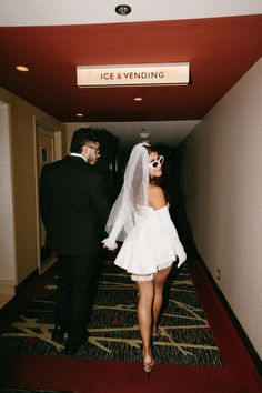 the bride and groom are walking down the hallway