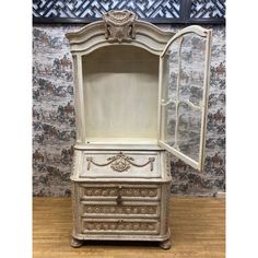 an antique white dresser with its doors open