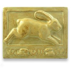 a gold colored metal stamp with a rabbit on it's back and the word wswuva written below