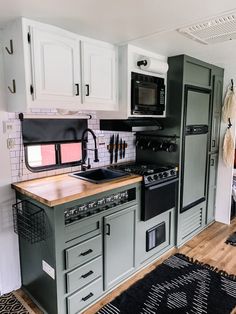 a kitchen with green cabinets and black appliances