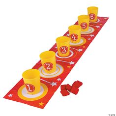 a red table runner with yellow cups and plates on it that have the number thirteen on them