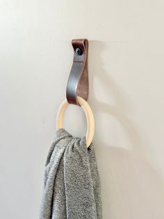 a towel hanging on the wall with a wooden ring attached to it's side