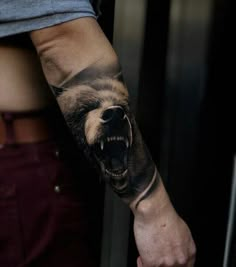 a man's arm with a bear tattoo on it and an open mouth in the middle