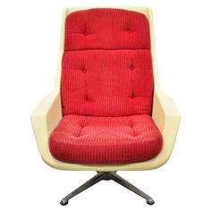 an office chair with a red seat cushion on it's back and silver legs