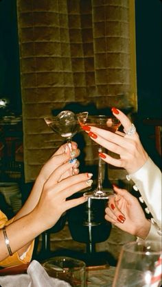 two women toasting with wine glasses at a table