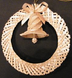 an ornament made out of wicker with a bell hanging from the front