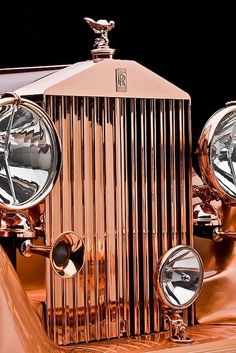 the front end of an old fashioned car with chrome grilles and mirrors on it