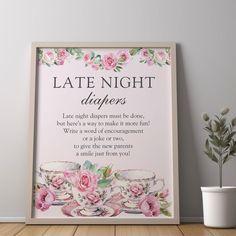 a framed poster with the words late night diapers and pink roses on it next to a potted plant