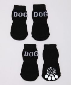 four pairs of black dog socks with white paw prints on the front and back of them