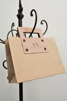 a brown paper bag on top of a black metal stand with a name tag attached to it