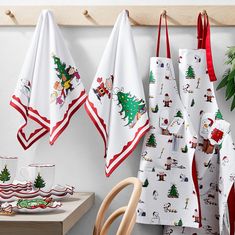 three christmas themed kitchen towels hanging on the wall next to a potted plant and coffee cup