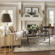 a living room filled with furniture and a fire place in front of a white fireplace