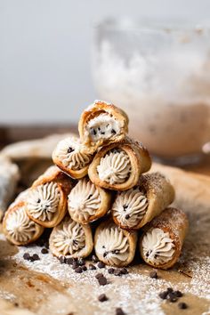 a pile of pastries sitting on top of a cutting board next to a bowl