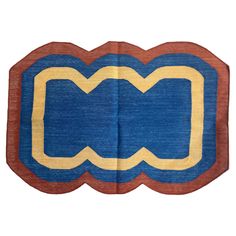 a blue and yellow rug with an oval design on the bottom, in front of a white background