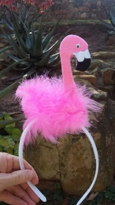 a pink flamingo headband with a black and white bird on it's forehead