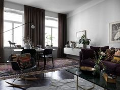 a living room filled with lots of furniture and decor on top of a carpeted floor