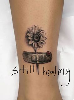 a woman's foot with a sunflower and knife tattoo on the side of her leg