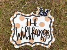 a sign that says the wild things on it in black and white polka dots with a bow