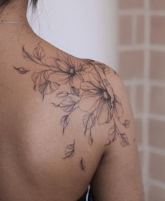 the back of a woman's shoulder with flowers on it