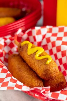 two hotdogs with mustard on them in baskets