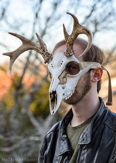 a man wearing a deer skull mask with horns