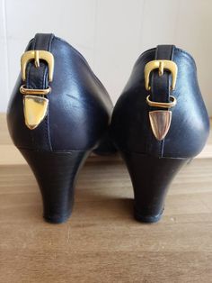 This is a pair of vintage, Michiel Luciano Michielon heels. They are navy blue leather with gold buckles on the back and are a size 38.5, which is an 8.5 US, but please take a look at the measurements below to ensure a proper fit. These are from the 1980s and are made in Italy. The tab of the buckle of the left shoe h has a problem. It's flaking. You can see this in the images. Their measurements are as follows: Interior Length: a hair over 10 inches Interior Width: 3 inches Heel Height at Highe Vintage Heels With Buckle Closure For Work, Vintage Heels For Work, Vintage Heels With Buckle Closure For Evening, Vintage Evening Heels With Buckle Closure, Vintage Gold Leather Heels, Vintage Heels With Buckle Closure And Pointed Toe, Formal Leather Heels With Gold Buckle, 3 Inch Heels, Women's Pumps