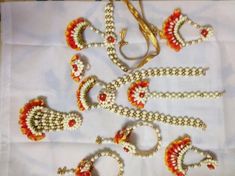 several pieces of beaded jewelry are laid out on a white tablecloth with gold trimmings